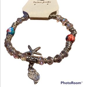 Clear beaded bracelet with silver charms